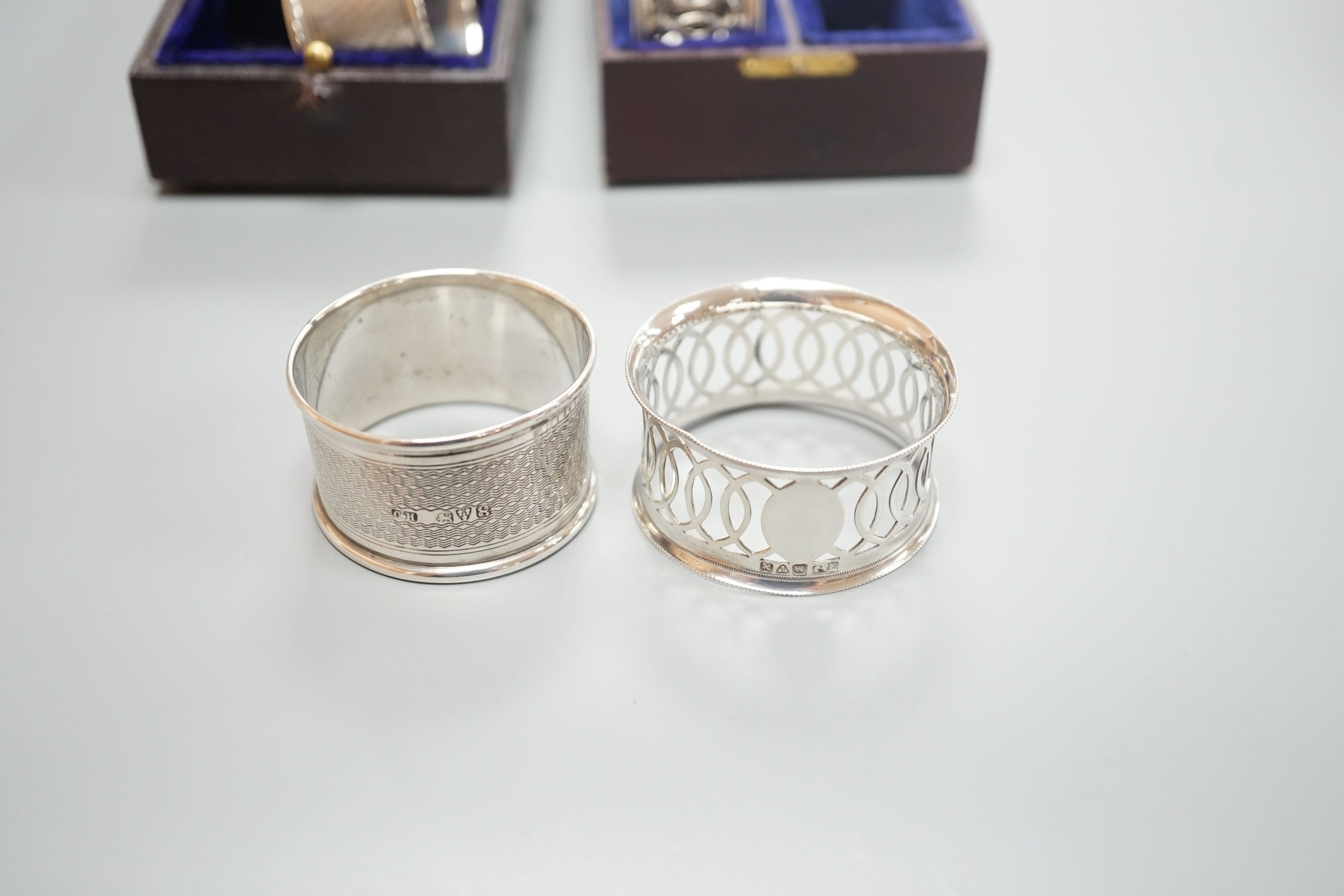 A cased pair of George V engine turned silver napkin rings, by Charles Horner, Chester, 1923 and an Edwardian cased pair of silver napkin rings.